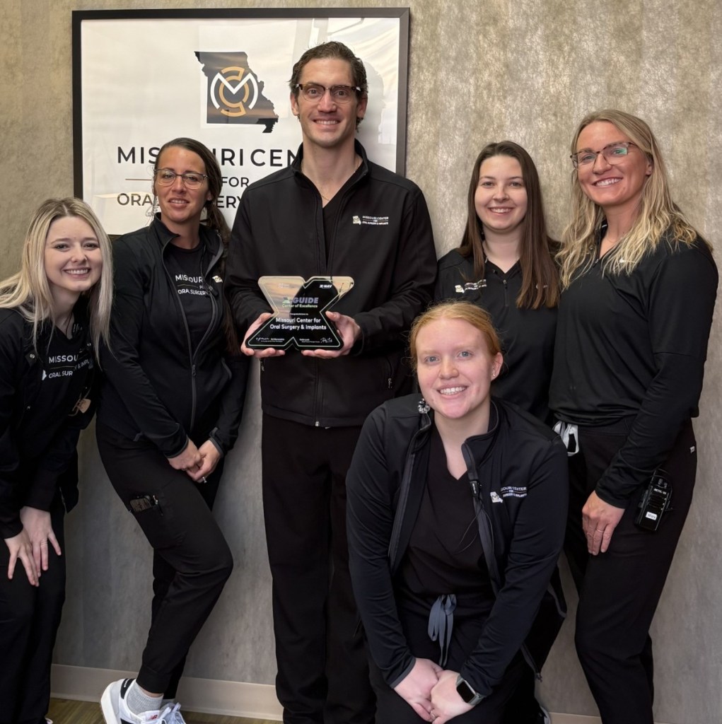 A group photo of Dr. Priddy and Wentzville staff members holding the X-Guide Center of Excellence Award.